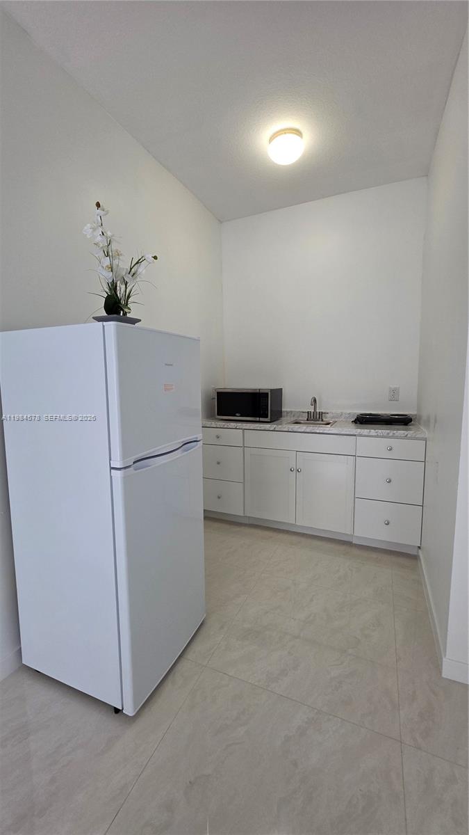 14552 Southwest 158th Court Miami, FL 33196 - Photo 19 of 21 a kitchen with white cabinets and white refrigerator