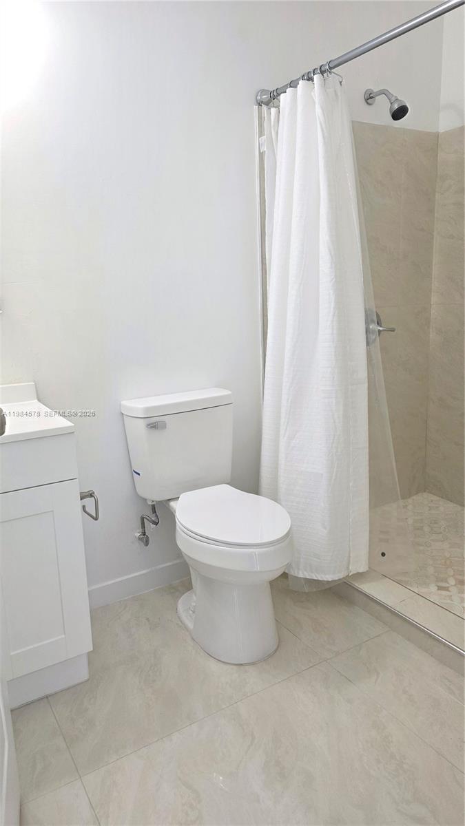 14552 Southwest 158th Court Miami, FL 33196 - Photo 21 of 21 a white toilet sitting next to a shower curtain