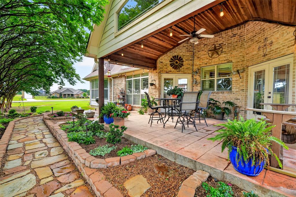 1399 Canyon Lake Road Wills Point, TX 75169 - Photo 29 of 37 a view of a patio with table and chairs potted plants and a palm tree