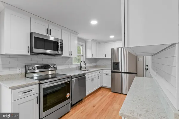 a kitchen with stainless steel appliances a stove microwave and refrigerator