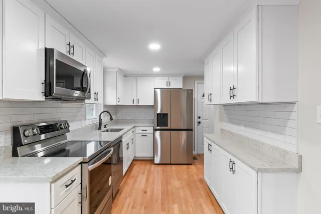 a kitchen with a sink a refrigerator a microwave and cabinets