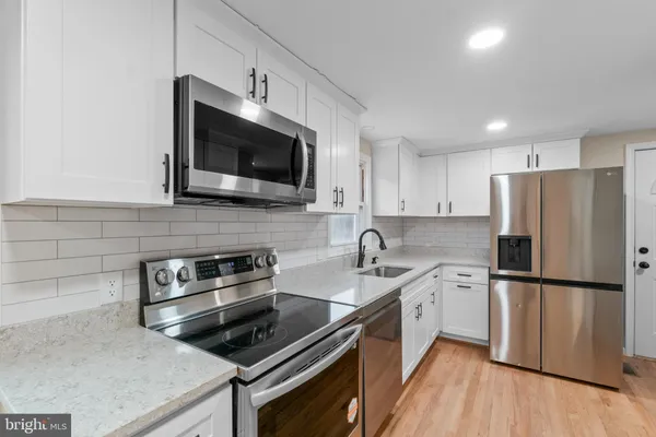 a kitchen with stainless steel appliances a stove microwave and sink