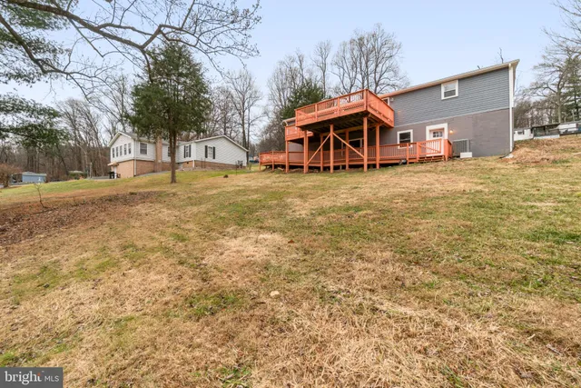 a view of a house with backyard and wooden fence