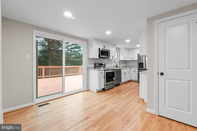 a kitchen with stainless steel appliances a stove top oven and a refrigerator