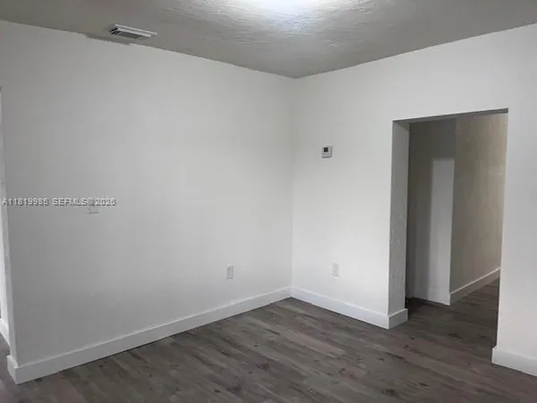 a view of an empty room with wooden floor