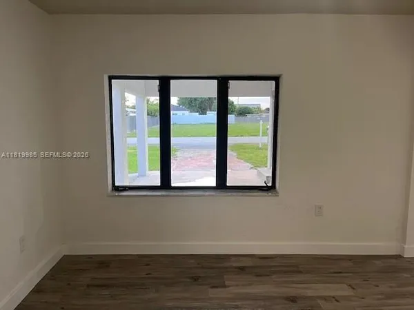 a view of a small space with wooden floor and a window