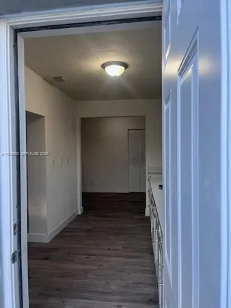 a view of a hallway with wooden floor