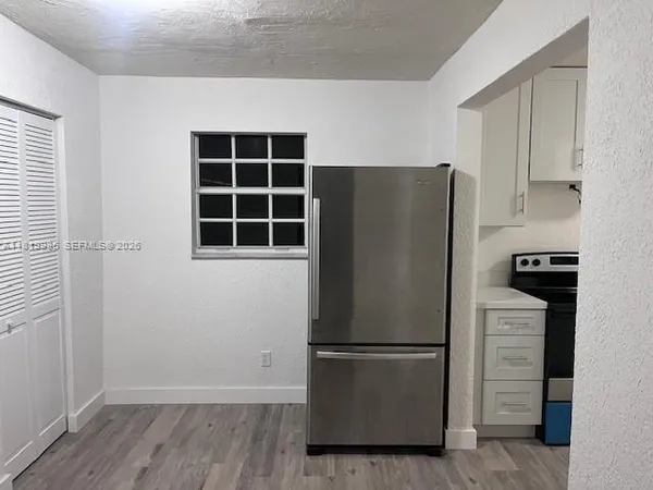 a white refrigerator freezer and a stove sitting inside of a kitchen