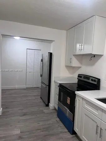 a kitchen with a refrigerator sink and cabinets