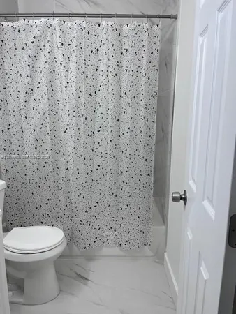a bathroom with a toilet and a shower curtain