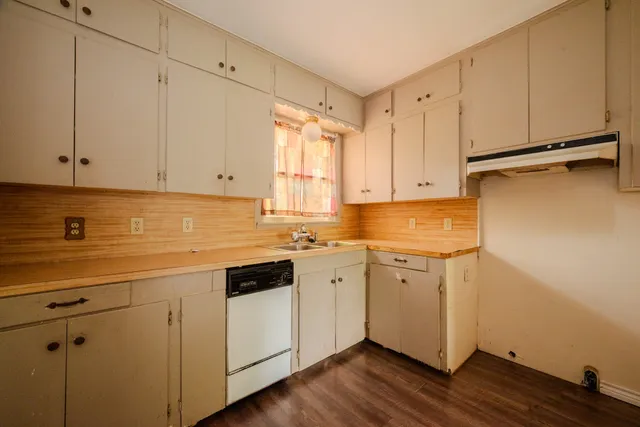 a room with a sink cabinets and a wooden floor