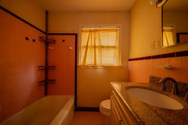 a view of a room with wooden floor and a ceiling fan