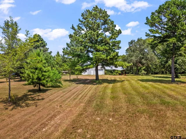 a view of yard with swimming pool and trees