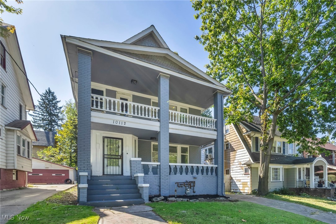 10112 Kinsman Road Cleveland, OH 44104 - Photo 2 of 49 View of front of house featuring brick siding, a porch, and a front lawn