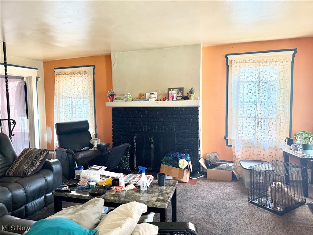Carpeted living room with plenty of natural light and a fireplace