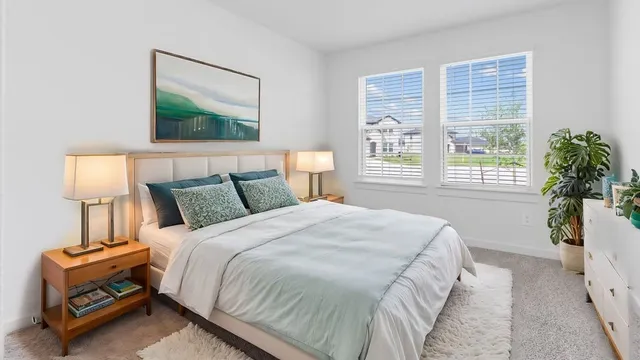 a bedroom with bed a lamp and a window