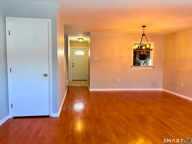 an empty room with a fireplace and wooden floor