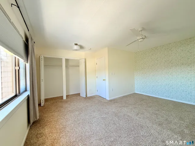 an empty room with fan and windows