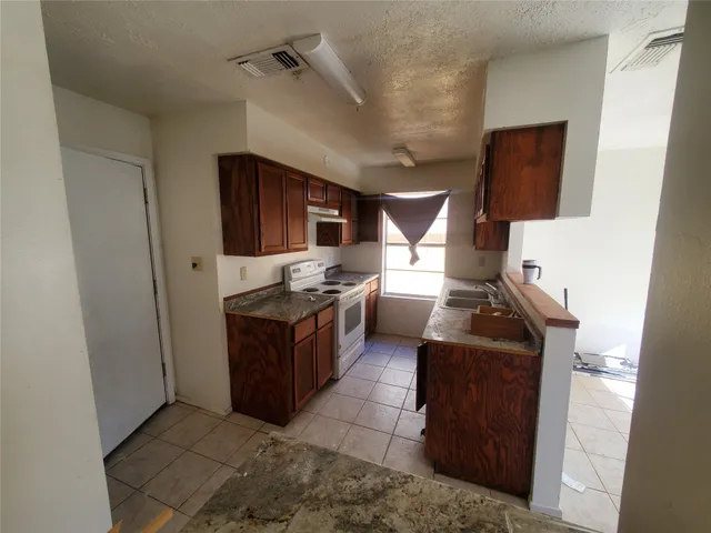 a kitchen with stainless steel appliances granite countertop a stove and a refrigerator