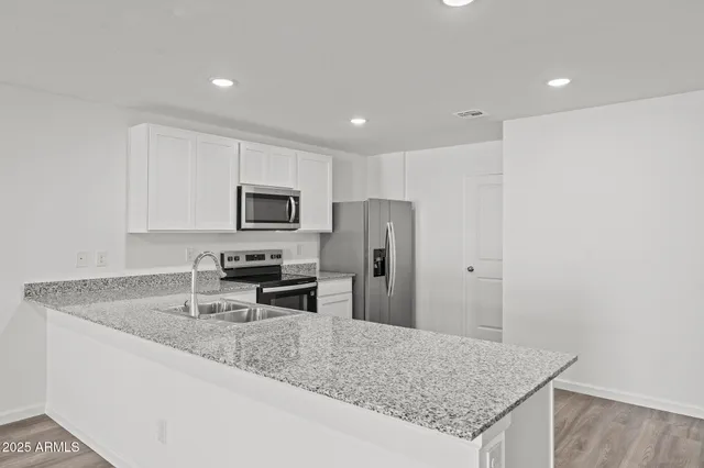 a kitchen with stainless steel appliances granite countertop a sink refrigerator and microwave