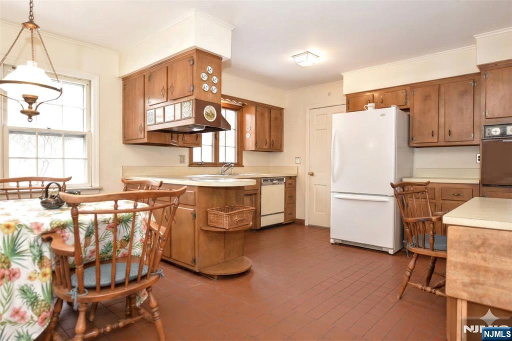 40 Hering Road Montvale, NJ 07645 - Photo 9 of 29 a kitchen with a refrigerator a stove a sink and white cabinets with wooden floor
