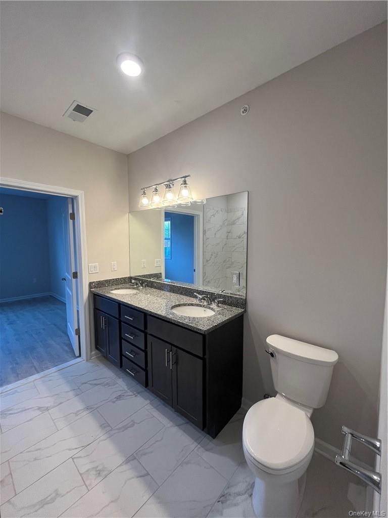 422 Tower Ridge Circle, Unit 422 Middletown, NY 10941 - Photo 7 of 17 a bathroom with a granite countertop toilet sink and mirror