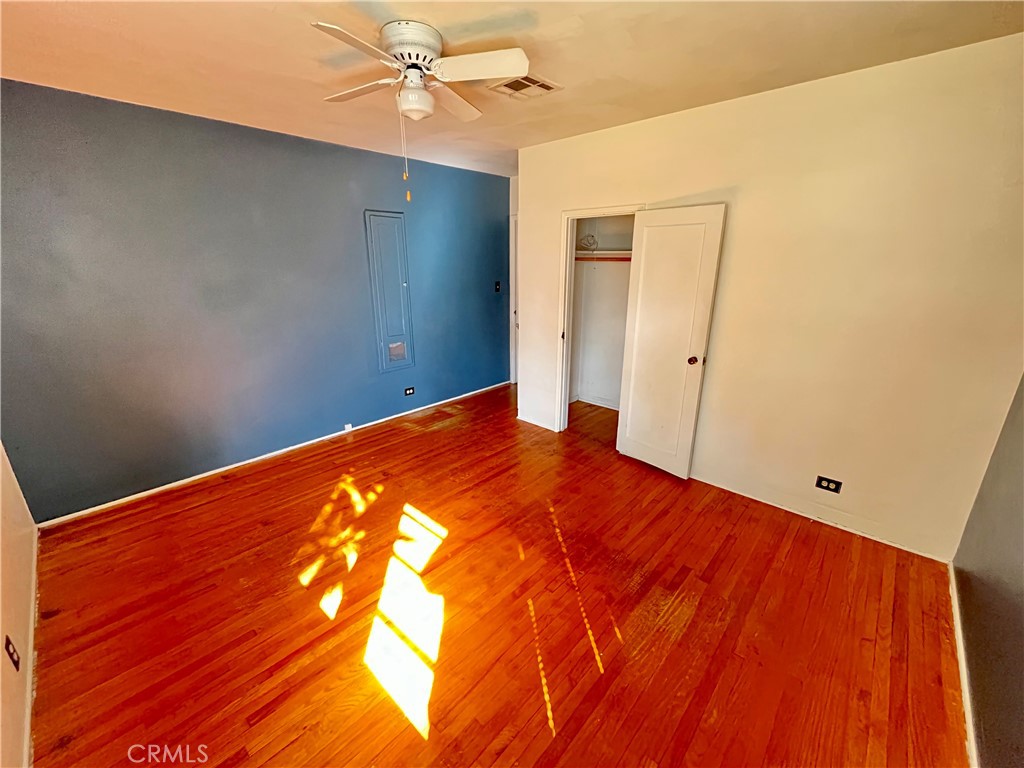 4245-4245 Homewood Court Riverside, CA 92506 - Photo 9 of 15 an empty room with wooden floor and fan