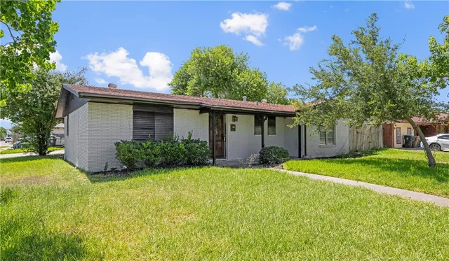 a view of a house with a yard and tree s