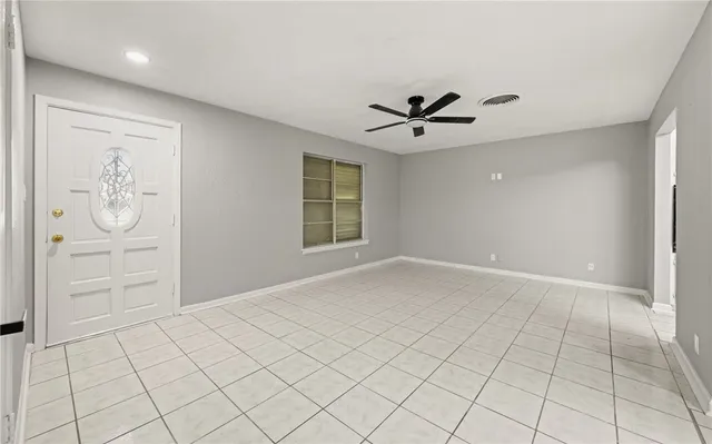 an empty room with windows and ceiling fan