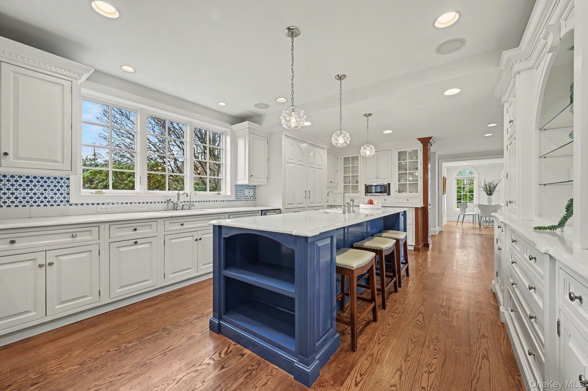 2 Park Drive South Rye, NY 10580 - Photo 21 of 50 a large kitchen with stainless steel appliances kitchen island granite countertop a large stove a sink dishwasher and white cabinets with wooden floor