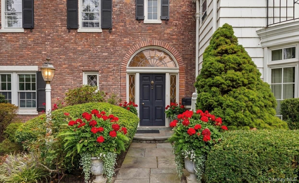 2 Park Drive South Rye, NY 10580 - Photo 3 of 6 A classic entry framed by a brick arch and fanlight. Bluestone path to front entrance.Planters virtually enhanced.