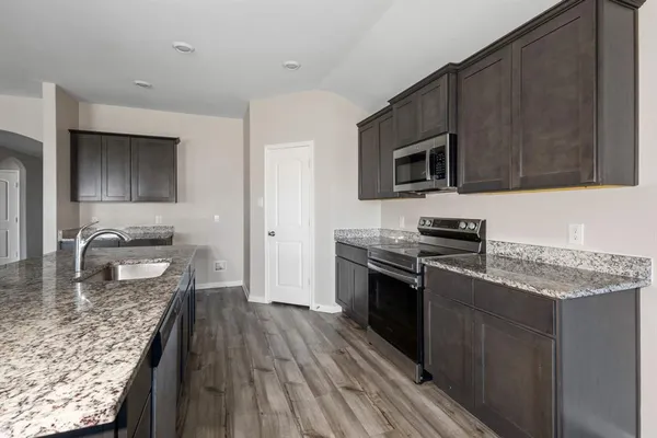 a kitchen with stainless steel appliances granite countertop a stove microwave and sink