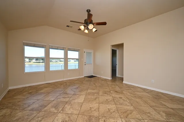 an empty room with a window and a fan