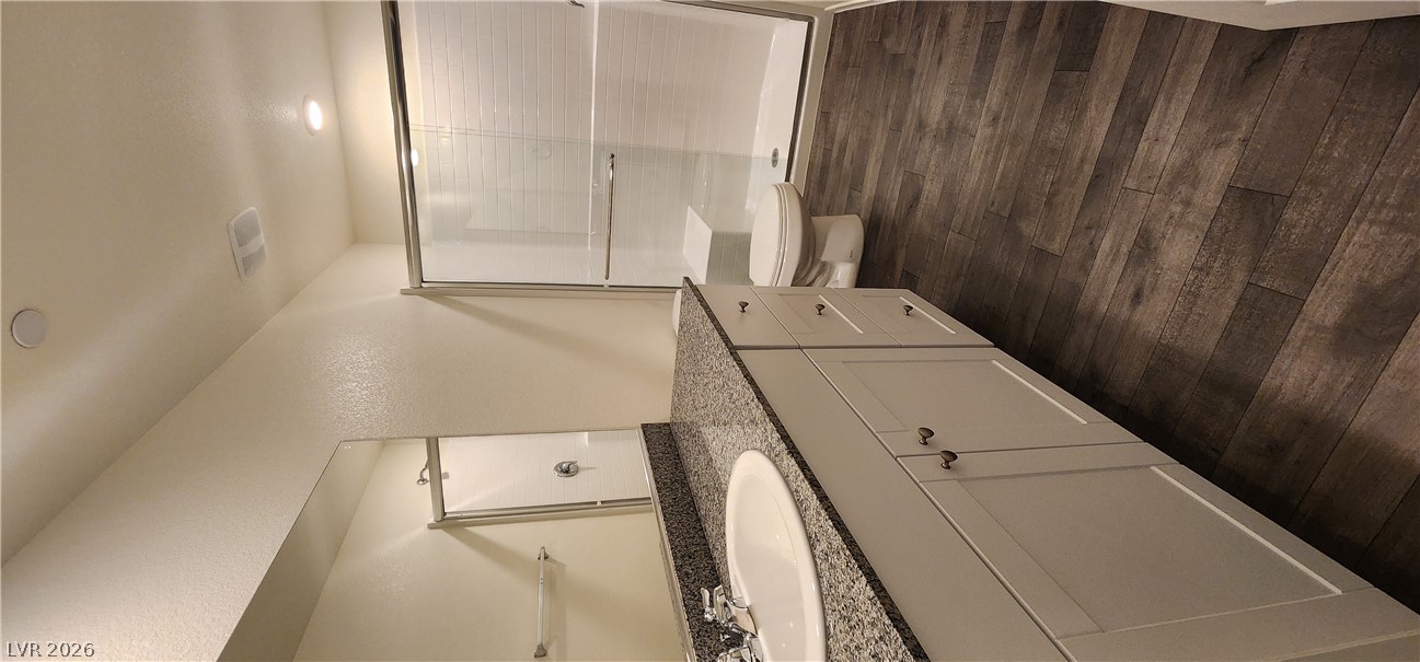 9127 Rory Storm Street Las Vegas, NV 89113 - Photo 14 of 27 Polished stone counters and clean tiled surfaces define this modern washroom space.