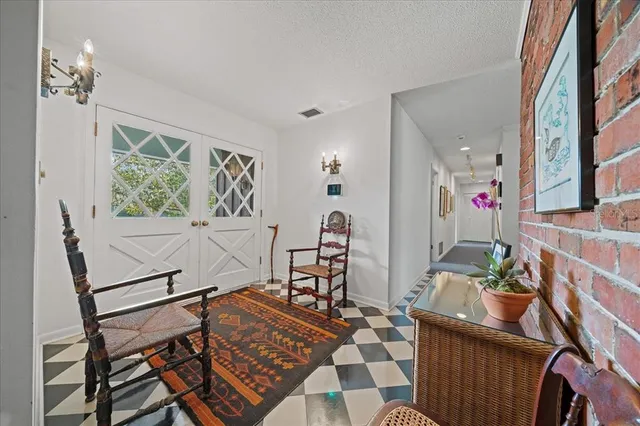 a view of a house with potted plants and a large tree