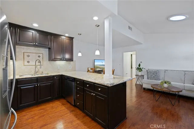 a kitchen with stainless steel appliances kitchen island granite countertop a sink counter space and cabinets