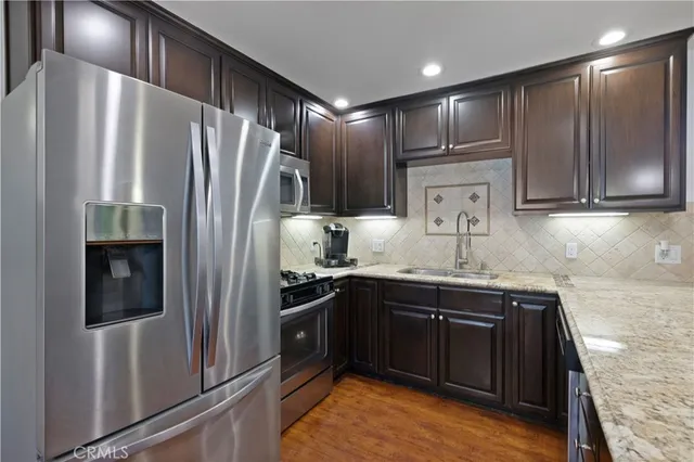 a kitchen with stainless steel appliances granite countertop a refrigerator and a sink