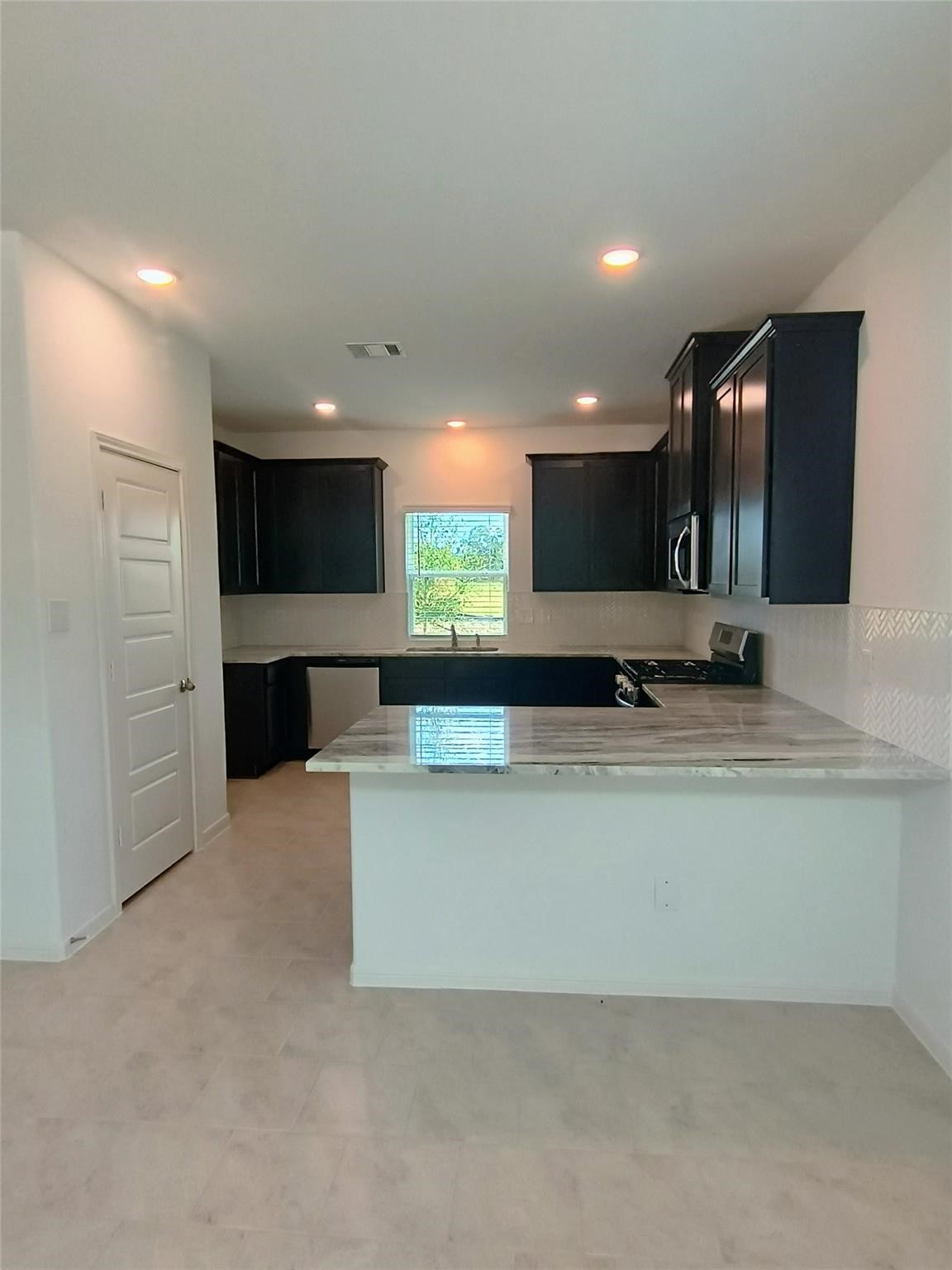 15924 Cy Young Court Splendora, TX 77372 - Photo 6 of 29 a large kitchen with stainless steel appliances a large counter top