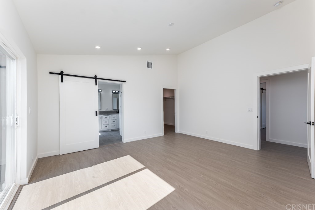 1177 Aztec Topanga, CA 90290 - Photo 38 of 65 a view of an empty room with wooden floor and a kitchen