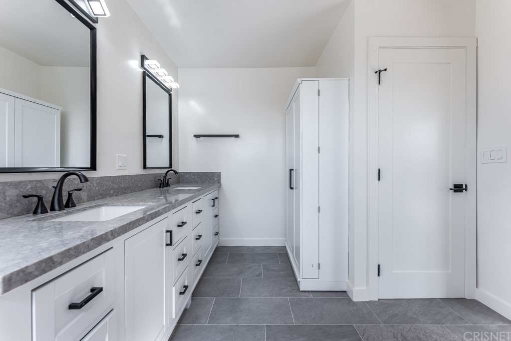 1177 Aztec Topanga, CA 90290 - Photo 41 of 65 a spacious bathroom with a granite countertop sink and a mirror