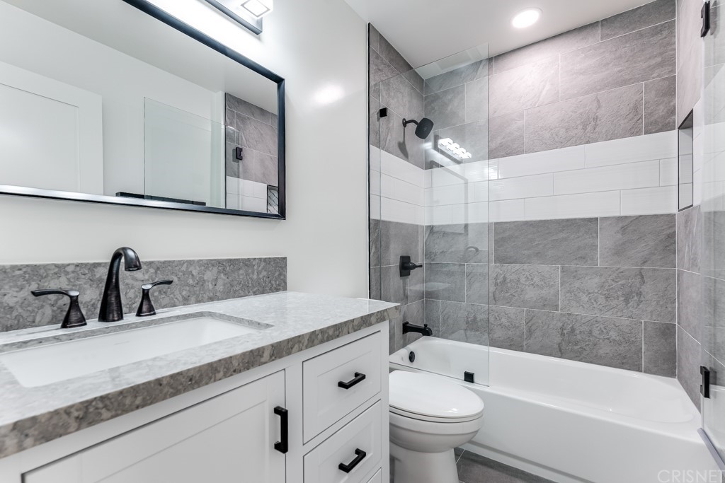 1177 Aztec Topanga, CA 90290 - Photo 49 of 65 a bathroom with a granite countertop sink a toilet a mirror and bathtub