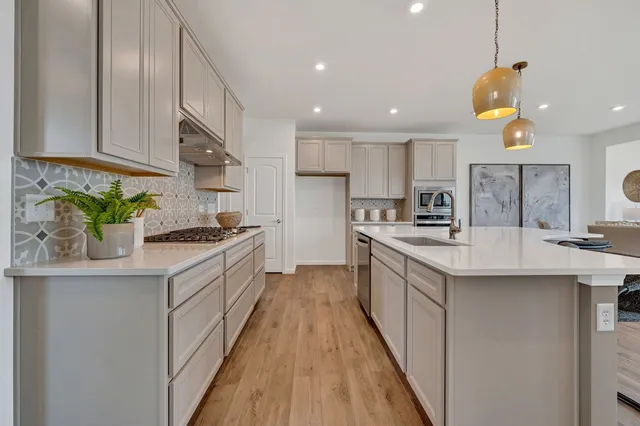 a kitchen with stainless steel appliances granite countertop a sink a stove and a refrigerator