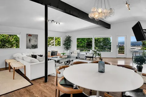 a view of a dining room with furniture a chandelier and wooden floor