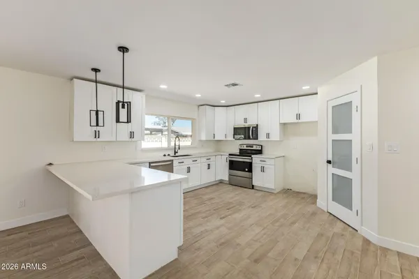 a kitchen with white cabinets and stainless steel appliances