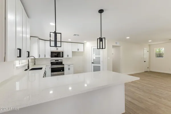 a kitchen with stainless steel appliances a refrigerator sink and microwave