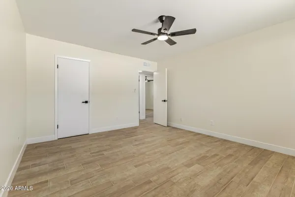 a view of a room with wooden floor and a ceiling fan