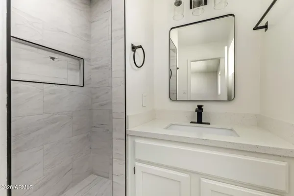 a bathroom with a granite countertop mirror sink and vanity