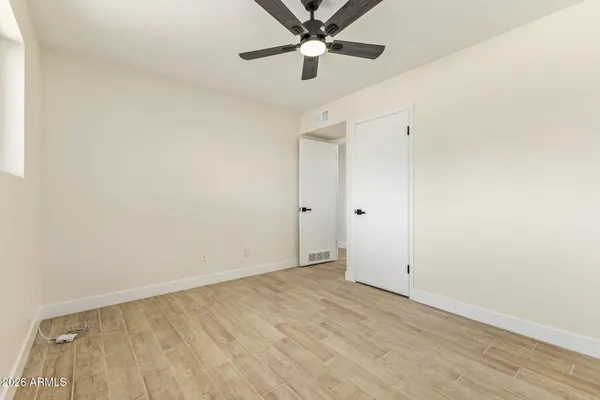 an empty room with a ceiling fan and carpet