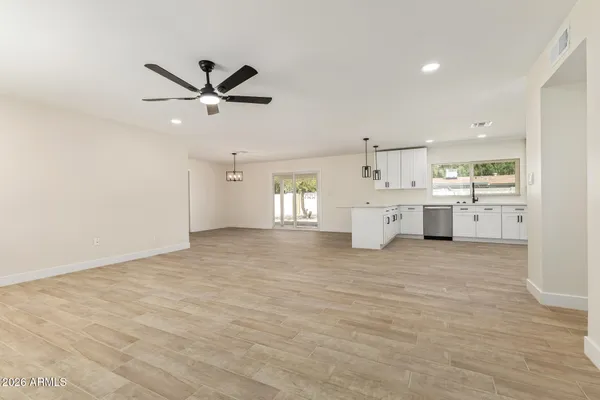 a big room with chandelier fan and windows