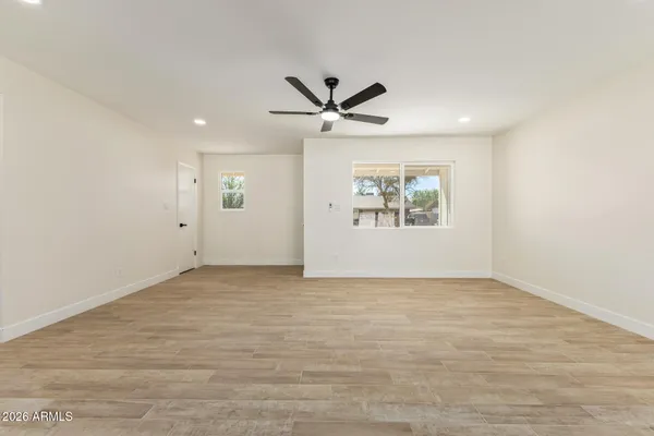 an empty room with fan and windows
